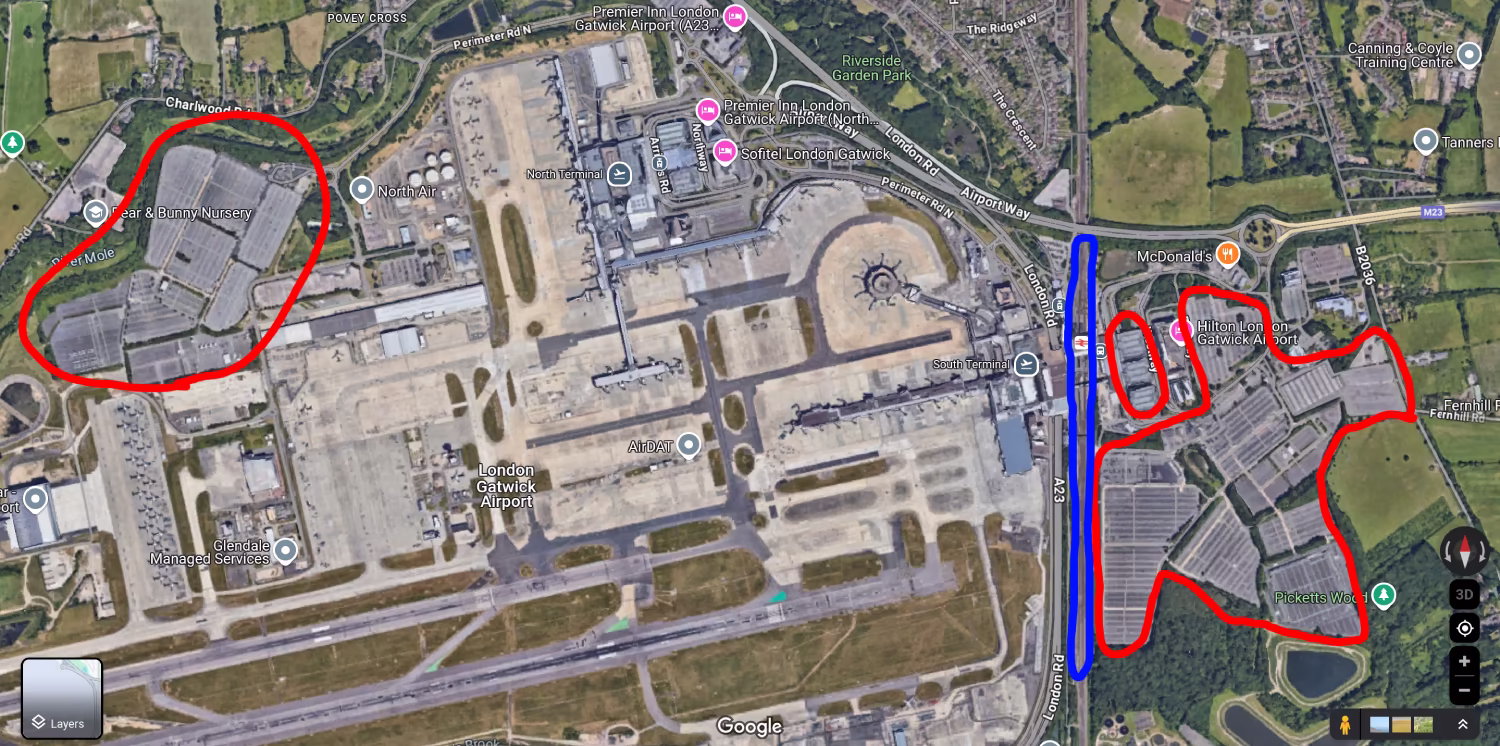 An arial view of London Gatwick Airport. The various car parks (short-stay, long-stay, holiiday parking) are circled in red, and the train line in blue. The train station is located next to the South terminal, whereas the car parks are located further out to the bottom-right and up in the top-left, and take up roughly 10-20x as much space.